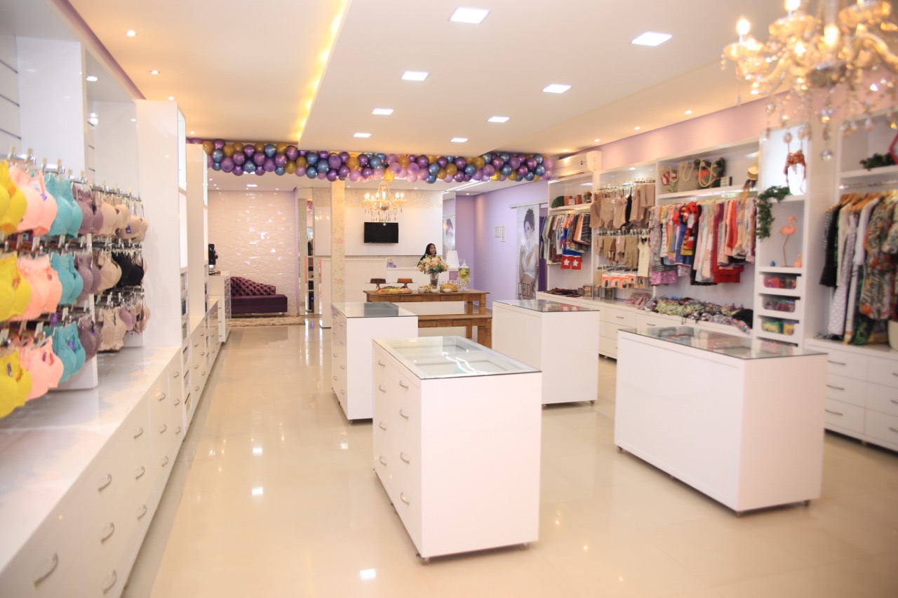 Interior da loja Led's Íntima com araras de lingerie coloridas e moda praia expostas